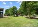 Expansive backyard with lush lawn, mature trees and partial view of the lake at 132 Flora Vista Dr, Mooresville, NC 28117