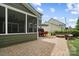 Backyard featuring a stone paver patio, screened porch, and lush landscaping at 132 Flora Vista Dr, Mooresville, NC 28117