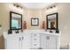 Charming bathroom with dual sinks, white cabinetry, modern fixtures, and stylish black hardware and framed mirrors at 132 Flora Vista Dr, Mooresville, NC 28117