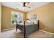 Comfortable bedroom with a wooden bed frame, ceiling fan, and natural light from a window, creating a serene retreat at 132 Flora Vista Dr, Mooresville, NC 28117