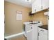 Bright laundry room with modern washer and dryer, storage cabinets, and decorative accents at 132 Flora Vista Dr, Mooresville, NC 28117