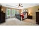 Spacious main bedroom with tray ceiling, a ceiling fan, carpet floors, and several windows for natural lighting at 132 Flora Vista Dr, Mooresville, NC 28117