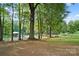 Scenic lakefront view showcasing a private dock with covered boat storage and natural surroundings at 132 Flora Vista Dr, Mooresville, NC 28117