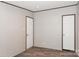 Bedroom showcasing modern wood-look floors, neutral walls, and two white doors at 1380 St. Johns Church Rd, Concord, NC 28025