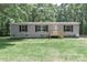 Inviting single-story home with gray siding, black shutters, and a newly-built wooden porch at 1380 St. Johns Church Rd, Concord, NC 28025
