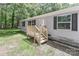 Inviting single-story home with gray siding, black shutters, and a newly-built wooden porch at 1380 St. Johns Church Rd, Concord, NC 28025