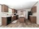 Modern kitchen with an island, black appliances, and wooden cabinets at 1380 St. Johns Church Rd, Concord, NC 28025