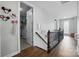 Bright hallway with hardwood floors, staircase with iron spindles, and a glimpse into a well-organized closet at 1437 Imperial Ct, York, SC 29745