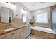 Bathroom featuring double vanity, soaking tub, decorative tile, and brass fixtures at 14505 Sunset Walk Ln, Huntersville, NC 28078
