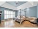 Bedroom with trey ceiling, four poster bed, hardwood floors, shuttered windows and pale blue walls at 14505 Sunset Walk Ln, Huntersville, NC 28078