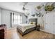Bright bedroom with hardwood floors, floral wall art, and neutral tones creates a relaxing retreat at 14505 Sunset Walk Ln, Huntersville, NC 28078