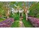 Charming two-story home featuring a welcoming porch, brick pathway, and lush landscaping, offering curb appeal at 14505 Sunset Walk Ln, Huntersville, NC 28078