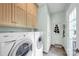 Laundry room with front load washer and dryer, tile floor and white storage cabinets at 14505 Sunset Walk Ln, Huntersville, NC 28078