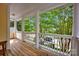 Inviting porch with white columns and wood floors, offering tranquil views of the leafy neighborhood at 14505 Sunset Walk Ln, Huntersville, NC 28078