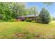 Backyard featuring lush lawn, surrounded by mature trees, hot tub and manicured landscaping at 151 Deja Ln, Cleveland, NC 27013