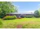 Backyard with brick house, patio and hot tub nestled among trees, offering a private outdoor retreat at 151 Deja Ln, Cleveland, NC 27013