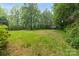 Expansive backyard with mature trees, featuring lush green grass with a utility shed at 151 Deja Ln, Cleveland, NC 27013
