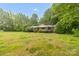 Charming brick home with a covered porch and mature trees in a spacious green front yard at 151 Deja Ln, Cleveland, NC 27013