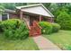 Inviting brick home entrance with covered porch and manicured greenery along the walkway at 151 Deja Ln, Cleveland, NC 27013