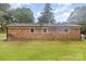Back view of the brick home with green grass, trees, and a satellite dish at 16 Green St, York, SC 29745