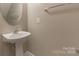 Modest half-bath with pedestal sink, oval mirror, and ceramic tile floors at 165 N Arcadian Way, Mooresville, NC 28117