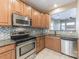 Well-lit kitchen featuring wooden cabinets, stainless steel appliances, and granite countertops at 165 N Arcadian Way, Mooresville, NC 28117