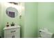 Charming half bath featuring marble countertops and modern finishes with a round mirror and white vanity at 17318 Cambridge Grove Dr, Huntersville, NC 28078