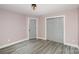 Bedroom features neutral walls, hardwood floors, closet, and a gray door at 17318 Cambridge Grove Dr, Huntersville, NC 28078