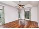 Spacious primary bedroom features hardwood floors, a tray ceiling, a ceiling fan, and floral curtains at 17318 Cambridge Grove Dr, Huntersville, NC 28078