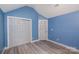 Bright bedroom with blue walls, vaulted ceiling, and a closet with white doors at 17318 Cambridge Grove Dr, Huntersville, NC 28078
