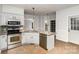 Bright kitchen features stainless steel appliances, granite counters, tile backsplash, and tiled flooring at 17318 Cambridge Grove Dr, Huntersville, NC 28078