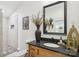 Stylish bathroom with a wooden vanity, black countertop, decorative mirror and tiled shower at 1737 Hwy 109 N Hwy, Troy, NC 27371