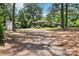 Secluded home surrounded by mature trees with a long driveway, detached garage, and front porch at 1737 Hwy 109 N Hwy, Troy, NC 27371