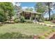 Attractive home with a covered porch and manicured lawn, complemented by mature trees offering shade at 1737 Hwy 109 N Hwy, Troy, NC 27371