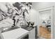 Laundry room featuring a large floral mural and modern appliances near the primary bedroom at 1737 Hwy 109 N Hwy, Troy, NC 27371