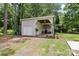 Spacious outbuilding surrounded by mature trees and green lawn near the home at 1737 Hwy 109 N Hwy, Troy, NC 27371