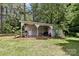 Rustic outbuilding surrounded by mature trees, green lawn and lush landscaping at 1737 Hwy 109 N Hwy, Troy, NC 27371