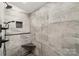 Beautiful shower with grey tile, black fixtures, and built-in stone shelves at 1737 Hwy 109 N Hwy, Troy, NC 27371