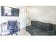 Bedroom featuring a dark colored couch, desk, and a large wall-mounted TV at 2009 Talbert Ct, Charlotte, NC 28214