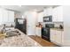 Kitchen featuring granite countertops, white cabinets, and black appliances with hardwood floors at 2009 Talbert Ct, Charlotte, NC 28214