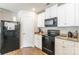 Well-lit kitchen with wooden floors, granite countertops, and black appliances at 2009 Talbert Ct, Charlotte, NC 28214