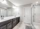 Bathroom featuring double sinks, dark cabinets, a large mirror and walk-in shower at 2178 Stone Pile Sw Dr, Concord, NC 28025