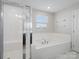 Bright, white bathroom with shower and a soaking tub at 2178 Stone Pile Sw Dr, Concord, NC 28025