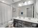 Bathroom featuring double sinks, dark cabinets, a large mirror and a shower with curtain at 2178 Stone Pile Sw Dr, Concord, NC 28025
