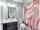Neutral toned bathroom with a dark vanity, a sink, toilet, mirror and a shower with patterned curtain at 2178 Stone Pile Sw Dr, Concord, NC 28025