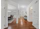Hallway displaying hardwood floors, white walls, wainscoting, arched entryway, and view of the dining room at 2178 Stone Pile Sw Dr, Concord, NC 28025