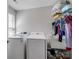 A white laundry room including a washer, dryer, shelving, and hanging space for delicate clothing at 2178 Stone Pile Sw Dr, Concord, NC 28025