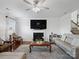 Bright living room featuring a fireplace, television, and hardwood flooring at 2178 Stone Pile Sw Dr, Concord, NC 28025