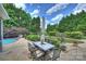 Outdoor dining area and lounge area with a beautiful in-ground pool surrounded by lush landscaping at 2300 Lord Anson Dr, Waxhaw, NC 28173