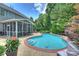 In-ground pool, screened-in porch, lush landscaping, and exterior view of the beautiful home at 2300 Lord Anson Dr, Waxhaw, NC 28173